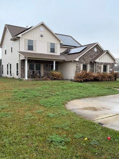 7 N Pine Rd, Texas City, TX 77591 - view of front of home featuring board and batten siding, roof mounted solar panels, a front lawn, and a porch