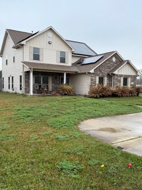 view of front of home with a front lawn and solar panels