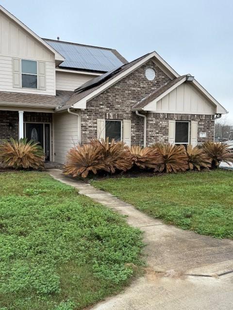7 N Pine Rd, Texas City, TX 77591 - traditional home featuring a front lawn, solar panels, and board and batten siding