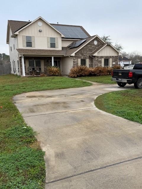 7 N Pine Rd, Texas City, TX 77591 - traditional home featuring board and batten siding, roof mounted solar panels, a front yard, and a porch