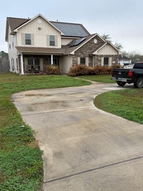 7 N Pine Rd, Texas City, TX 77591 - traditional-style house featuring board and batten siding, roof mounted solar panels, a front yard, covered porch, and driveway