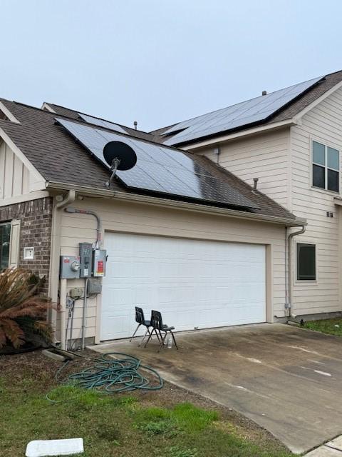 7 N Pine Rd, Texas City, TX 77591 - view of side of property with driveway, solar panels, a garage, and a shingled roof