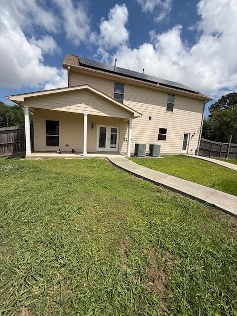 7 N Pine Rd, Texas City, TX 77591 - rear view of house with roof mounted solar panels, french doors, central air condition unit, and a patio