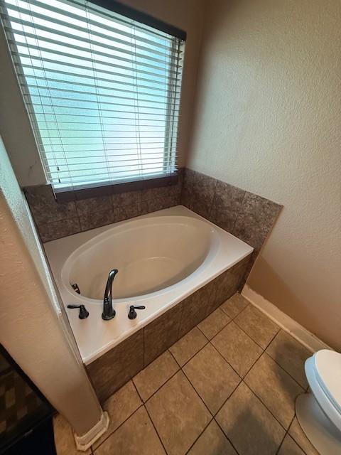 7 N Pine Rd, Texas City, TX 77591 - bathroom with a bath, tile patterned flooring, and toilet