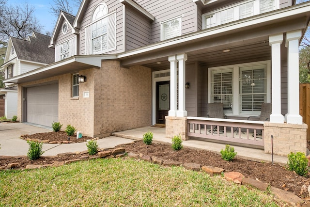 entrance to property featuring a garage and a porch