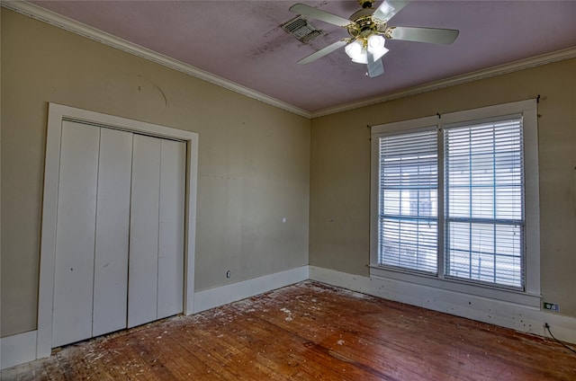 unfurnished bedroom featuring crown molding, wood-type flooring, a closet, and ceiling fan