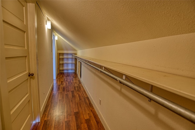 corridor with lofted ceiling and dark wood-type flooring