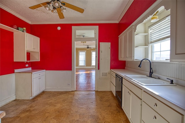 kitchen featuring a healthy amount of sunlight, black dishwasher, sink, and white cabinets