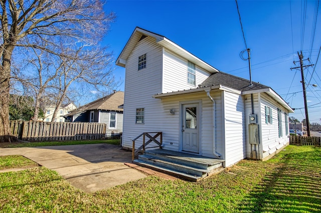 rear view of property with a lawn and a patio