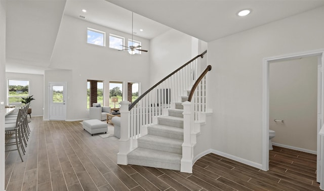 entryway with ceiling fan, plenty of natural light, and a towering ceiling