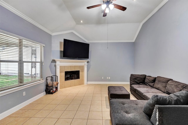 living room featuring crown molding, a tile fireplace, ceiling fan, light tile patterned flooring, and vaulted ceiling