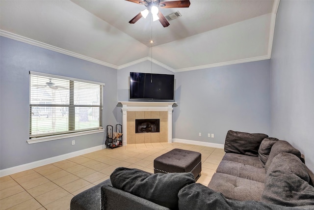 tiled living room with ceiling fan, lofted ceiling, a tile fireplace, and ornamental molding