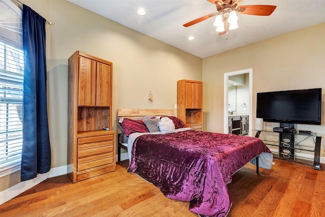 bedroom with ceiling fan, ensuite bathroom, and light hardwood / wood-style flooring