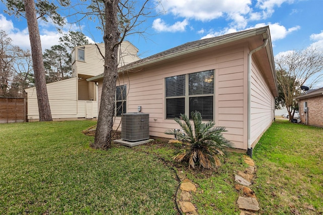 rear view of property featuring central AC unit and a yard