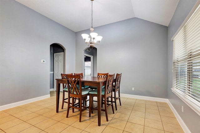 dining area featuring lofted ceiling, light tile patterned floors, and a chandelier