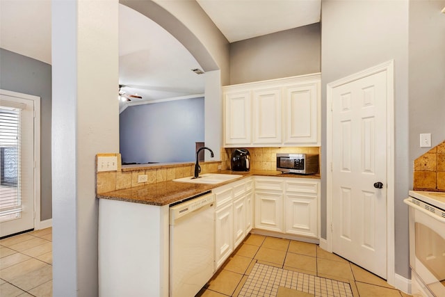 kitchen with sink, light tile patterned floors, stone counters, white appliances, and decorative backsplash