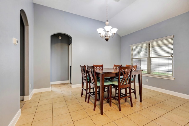 dining room with an inviting chandelier, vaulted ceiling, and light tile patterned floors