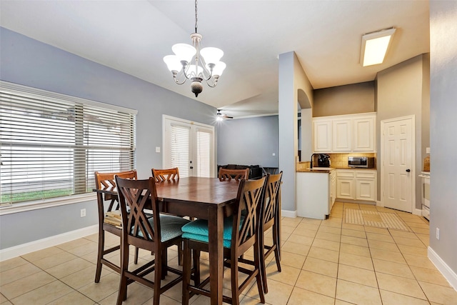 dining space featuring light tile patterned flooring, lofted ceiling, french doors, and a notable chandelier