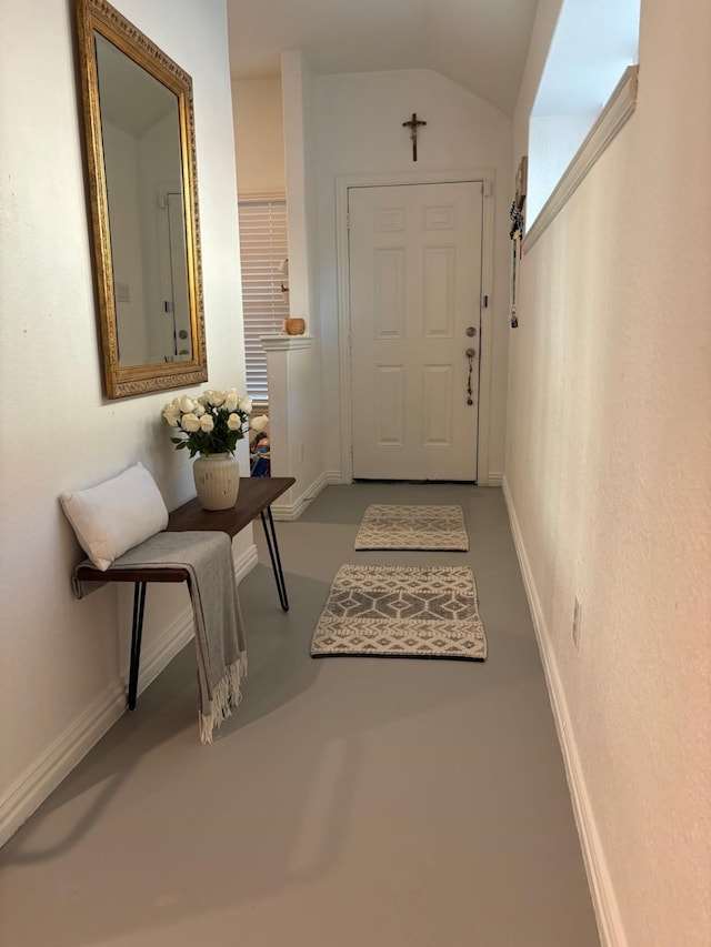 entryway featuring vaulted ceiling and concrete flooring