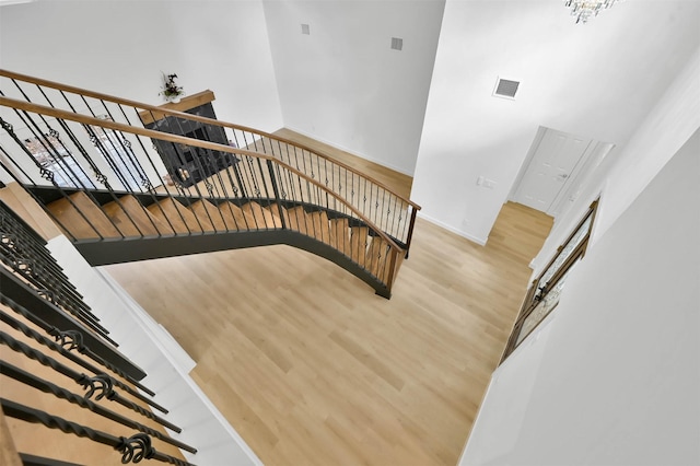 staircase with hardwood / wood-style flooring and a towering ceiling