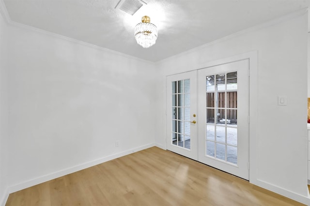 interior space featuring crown molding, light hardwood / wood-style flooring, a notable chandelier, and french doors