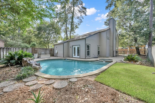 view of pool featuring an in ground hot tub, a yard, and french doors