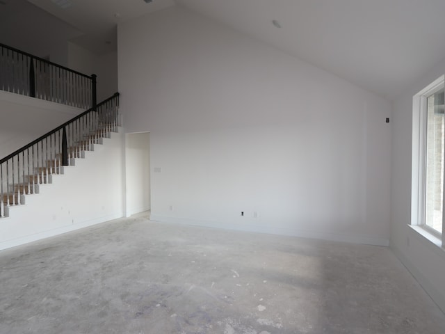 8315 Oceanmist Cove Dr, Cypress, TX 77433 - unfurnished living room with high vaulted ceiling, concrete flooring, baseboards, and stairs