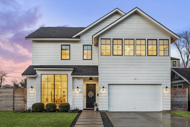 view of front of home with a garage and a lawn