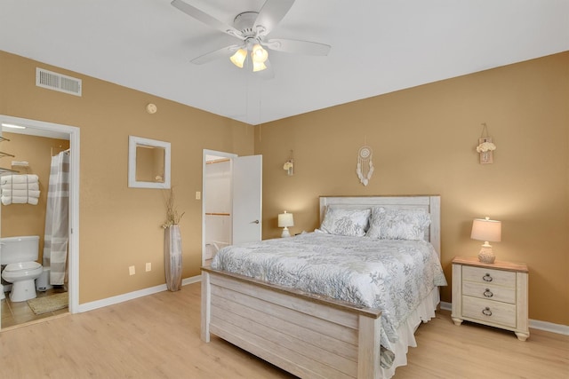 bedroom with light wood-style floors, visible vents, ensuite bath, and baseboards