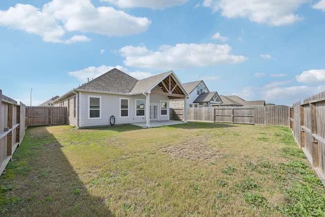 back of house with a yard and a patio