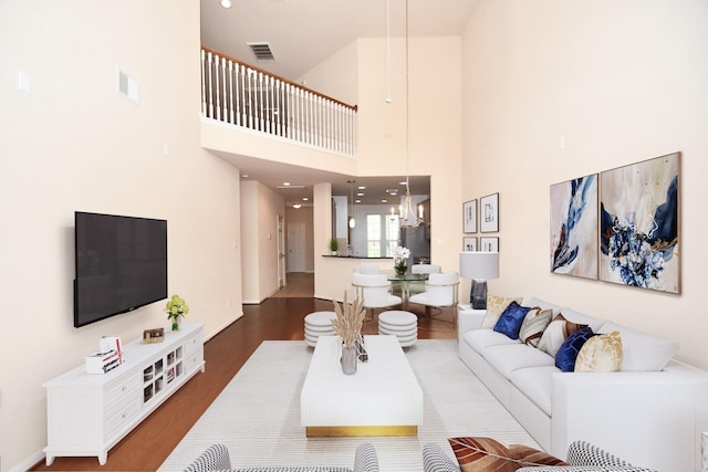 living room with a notable chandelier and dark hardwood / wood-style floors