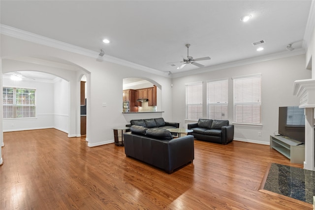 living room featuring ceiling fan, ornamental molding, and hardwood / wood-style floors