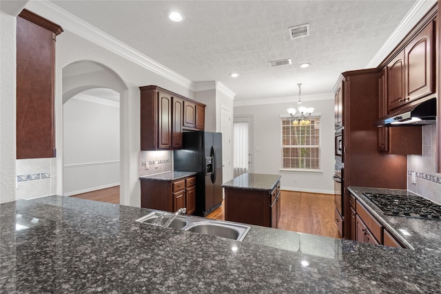 kitchen featuring sink, light wood-type flooring, ornamental molding, decorative backsplash, and black appliances