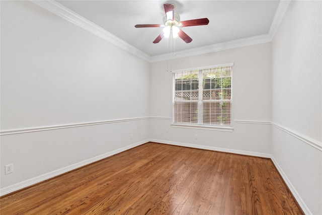 spare room with baseboards, a ceiling fan, wood finished floors, and crown molding