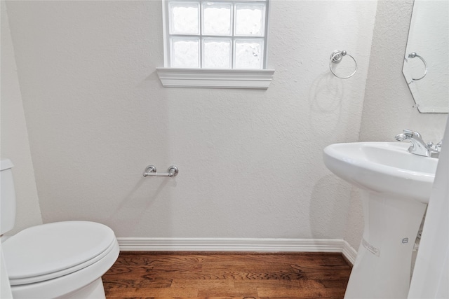 bathroom with wood-type flooring and toilet