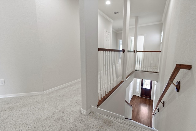 stairway with crown molding, a high ceiling, baseboards, and visible vents