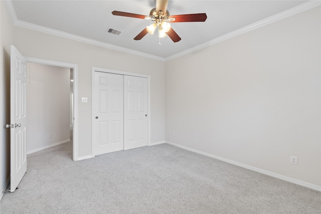 unfurnished bedroom featuring light carpet, crown molding, a closet, and ceiling fan