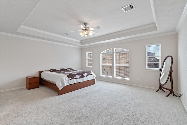 bedroom featuring visible vents, baseboards, and a tray ceiling