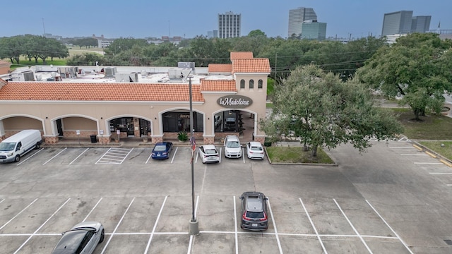 uncovered parking lot featuring a view of city