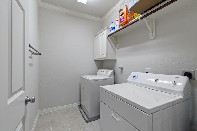 laundry area with baseboards, light tile patterned flooring, cabinet space, crown molding, and washer and clothes dryer