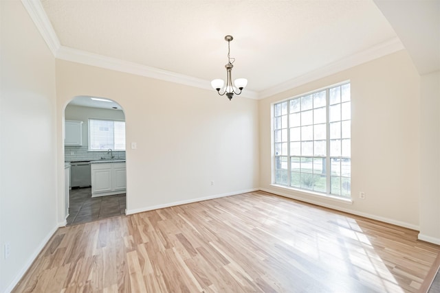 empty room featuring ornamental molding, light hardwood / wood-style flooring, and a wealth of natural light