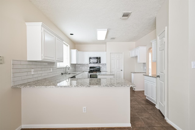 kitchen with sink, stainless steel stove, kitchen peninsula, and white cabinets