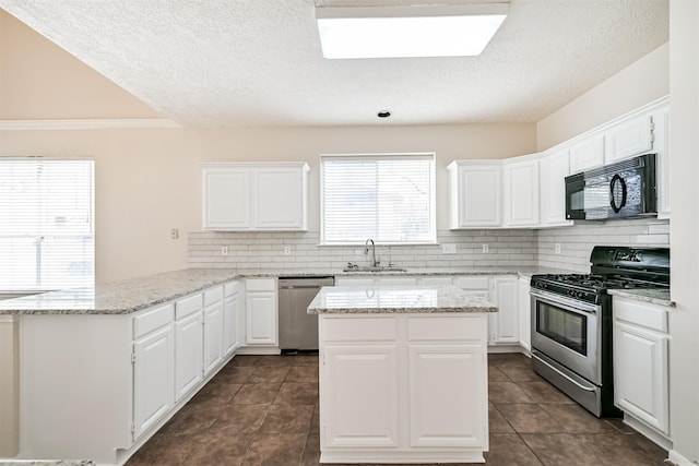 kitchen with sink, appliances with stainless steel finishes, light stone counters, tasteful backsplash, and white cabinets