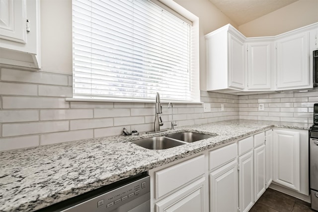 kitchen featuring sink, dishwasher, tasteful backsplash, light stone countertops, and white cabinets