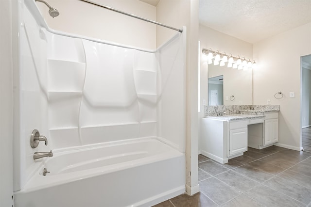 bathroom featuring vanity, tile patterned floors, bathing tub / shower combination, and a textured ceiling