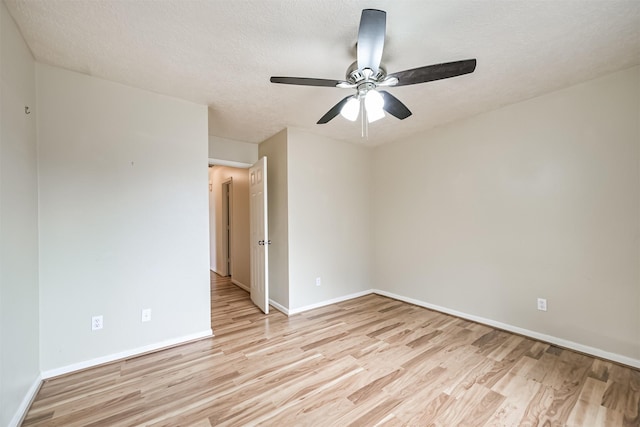 spare room featuring ceiling fan, light hardwood / wood-style flooring, and a textured ceiling