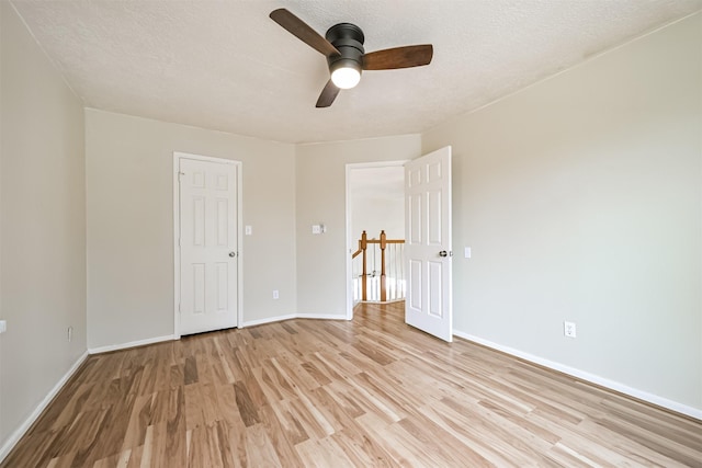 unfurnished bedroom with ceiling fan, a textured ceiling, and light wood-type flooring