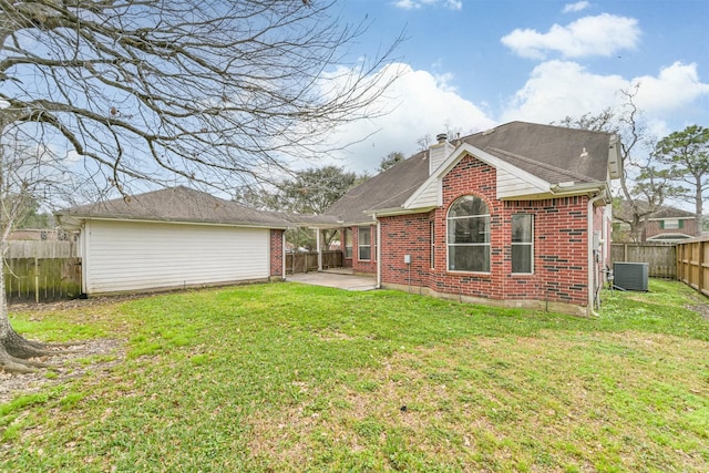 back of property with a patio, central AC, and a lawn