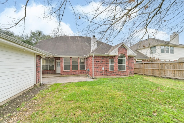 back of house featuring a patio area and a lawn