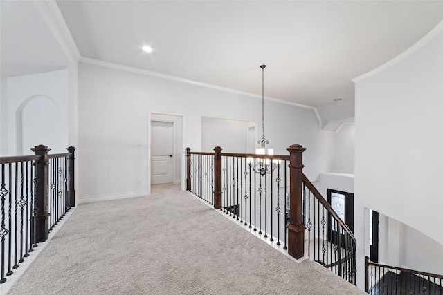 hall with baseboards, an upstairs landing, light colored carpet, and ornamental molding
